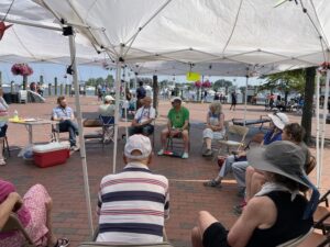 Individuals seated in circle at City Dock for Peace Vigil 